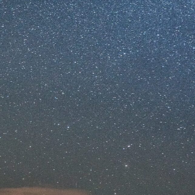 To tettere varmer seg på et bål under stjernehimlen, fotokunst veggbilde / plakat av Bård Basberg