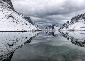 Fjellrekke som speiler seg i fjord., fotokunst veggbilde / plakat av Klaus Axelsen