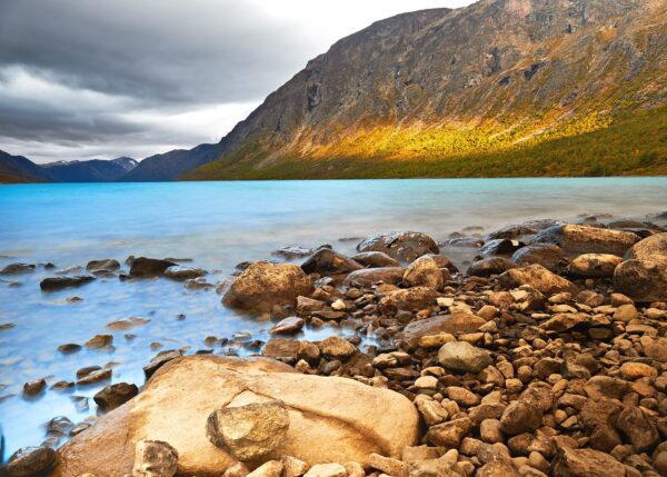 Stille vann mot stein og morgensol i fjellsiden, fotokunst veggbilde / plakat av Peder Aaserud Eikeland