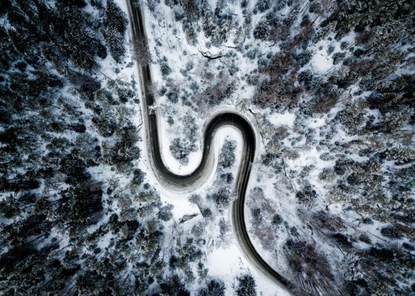 Et dronebilde ovenfra som viser kontrast mellom snø og vei, fotokunst veggbilde / plakat av Tor Arne Hotvedt