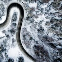 Et dronebilde ovenfra som viser kontrast mellom snø og vei, fotokunst veggbilde / plakat av Tor Arne Hotvedt
