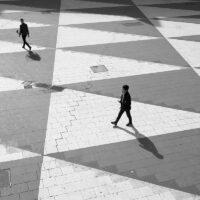 To personer som går på sorte og hvite trekanter, fotokunst veggbilde / plakat av Tor Arne Hotvedt