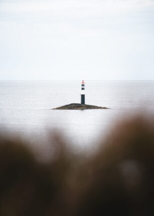 Et enslig fyrtårn på sin egen øy ved Atlanterhavsveien, fotokunst veggbilde / plakat av Tor Arne Hotvedt